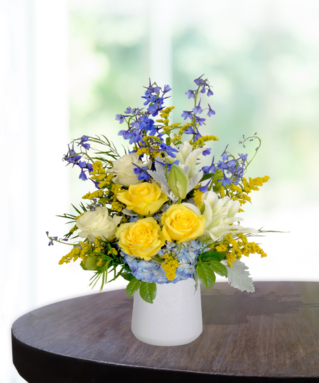 Sassy Sapphire flower arrangement with blue delphiniums, white lilies, and seasonal blooms