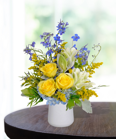 Sassy Sapphire flower arrangement with blue delphiniums, white lilies, and seasonal blooms