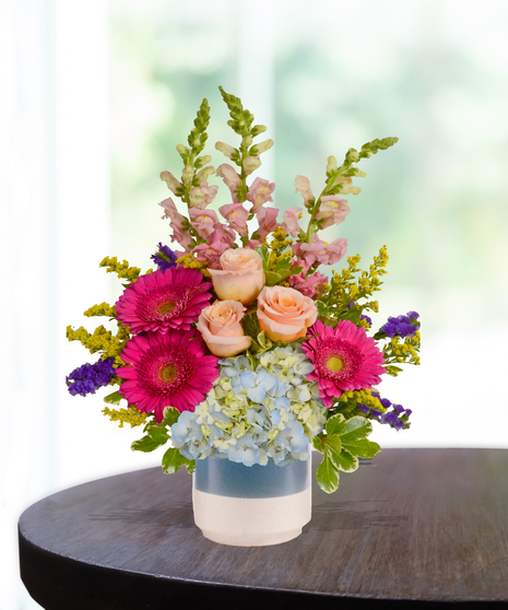 pink flowers and roses in a cream vase