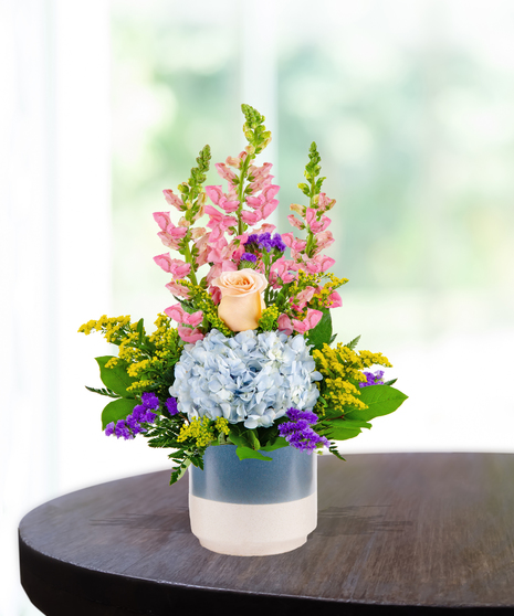 pink flowers and roses in a cream vase